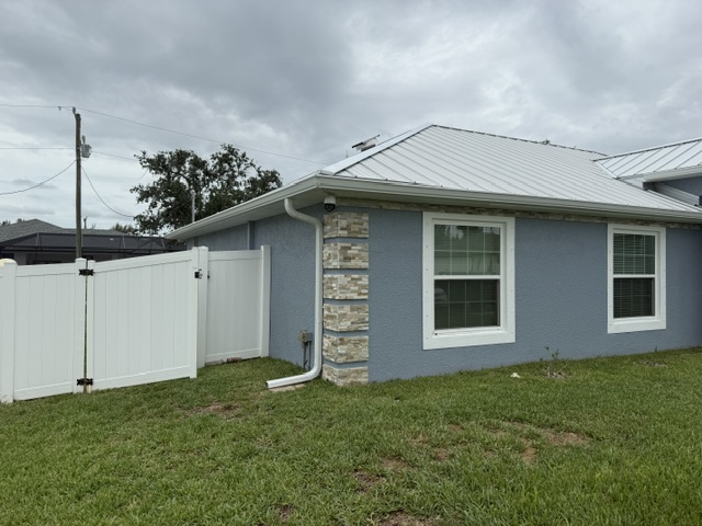 White gutter and corner downspout on a blue home
