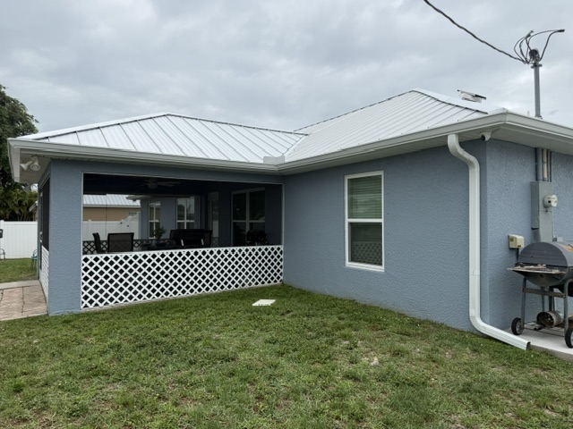 White gutters and downspout beside an open patio