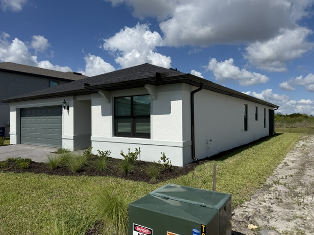 Dark gutter installation along a white home's side