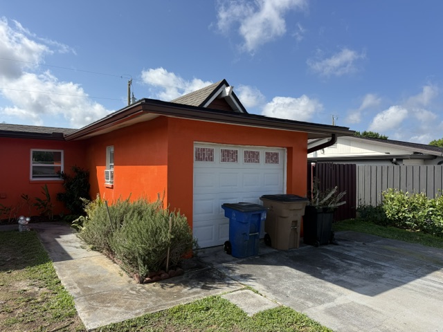 Dark gutter across an orange home's garage roofline