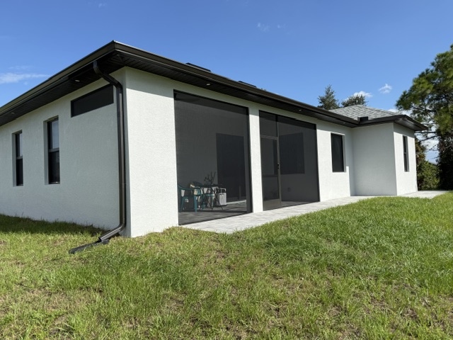 Black screen panels enclosing a white home's lanai